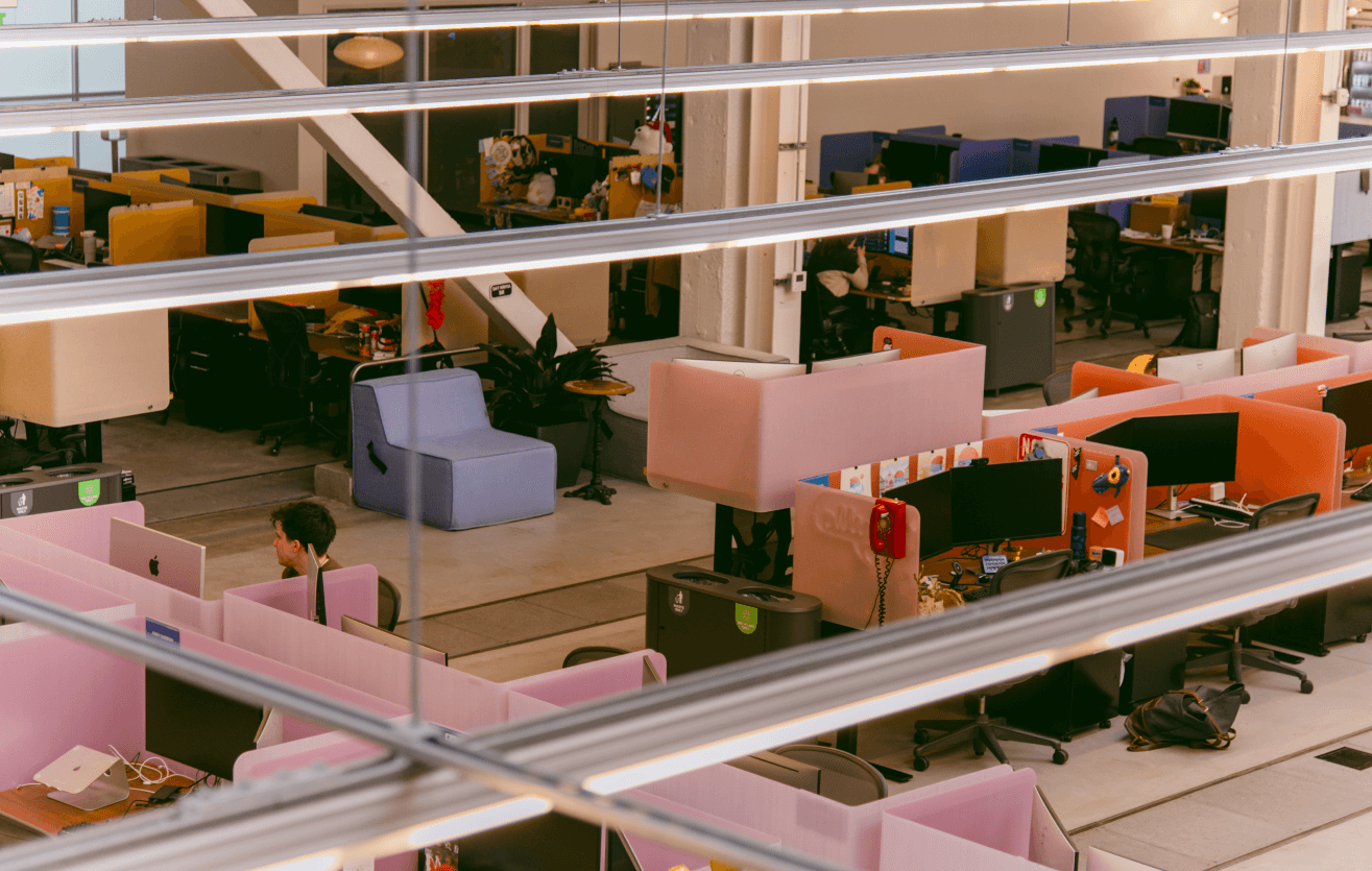 Discord’s office — a comfortable arrangement of various seating options, computer equipment, individual desks, and Discord employees at work.